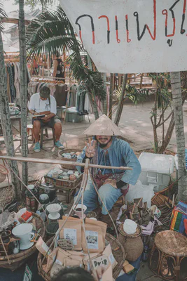 Choo Jai shows three fingers to indicate the price of a bag: 300 Baht.