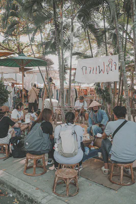 Several people sitting around Choo Jai, waiting for their coffee.